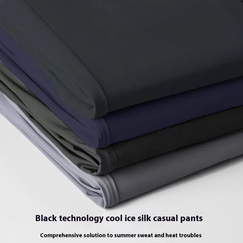Man wearing black Ice Silk loose-fit straight-leg trousers with an elasticated waist for casual leisure wear.