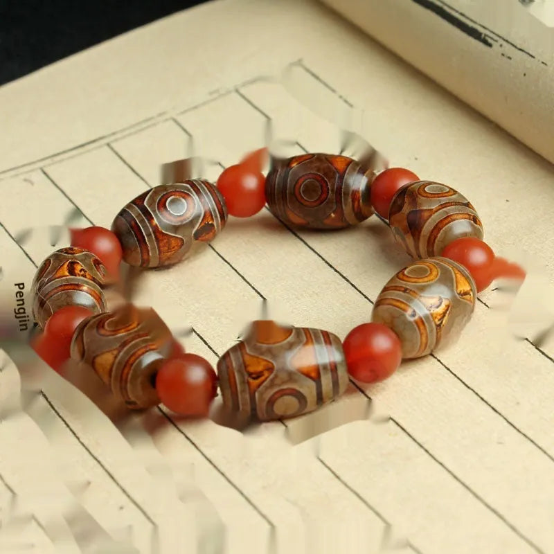 Distressed agate bracelet with traditional Tibetan dzi beads including three-eye and Nine Eyes designs.