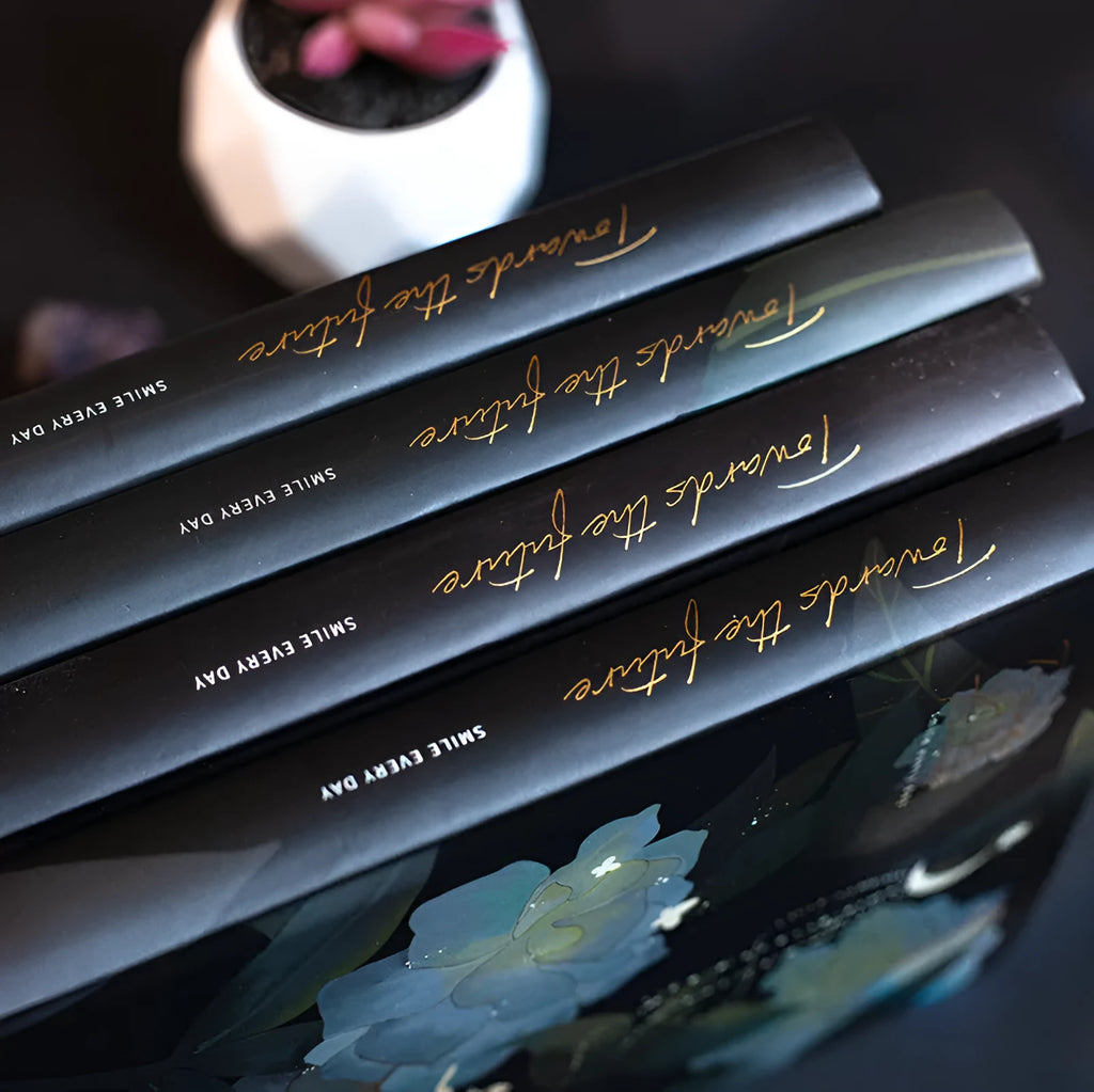 A5 notebook with luminous holographic cover lying flat, showing colourful illustrated interior pages.