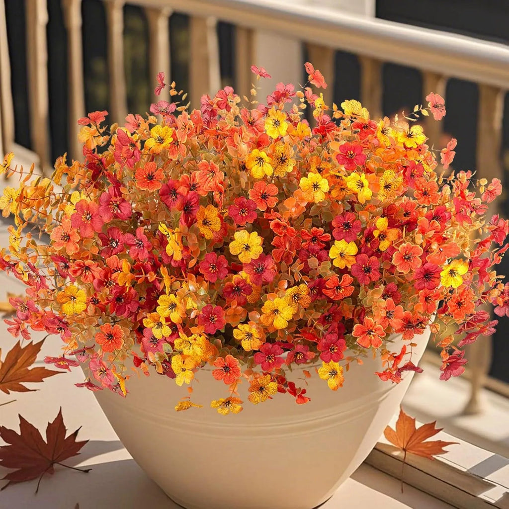 Artificial flower bouquet in autumn orange, red, and yellow colours for home and event decoration.