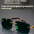 Frameless dark green crystal glasses with sunshade function shown with case and cleaning cloth