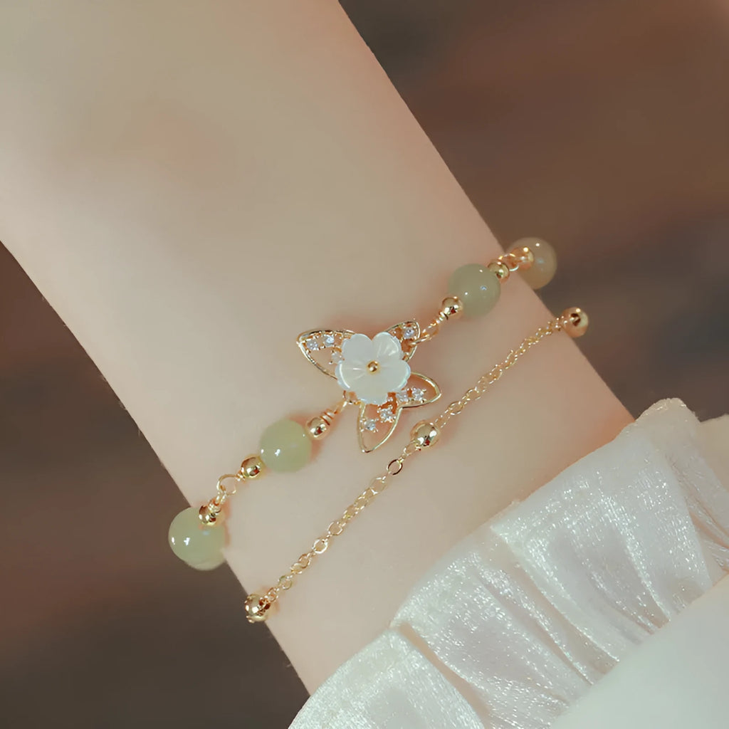 Yellow gold electroplated copper bracelet with shell flower butterfly charm containing Hetian jade elements