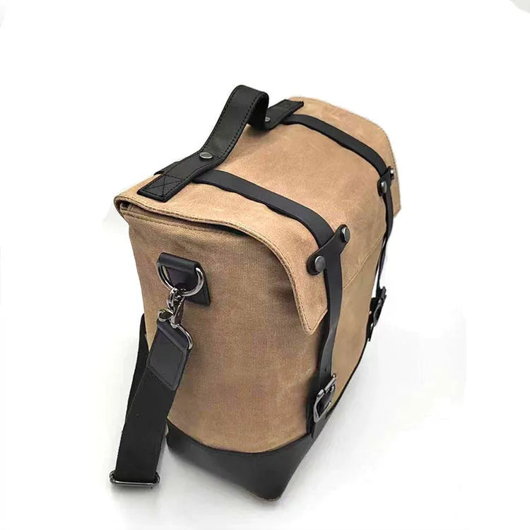 Motorcycle side pannier bag in black made from waterproof canvas with cowhide trim.