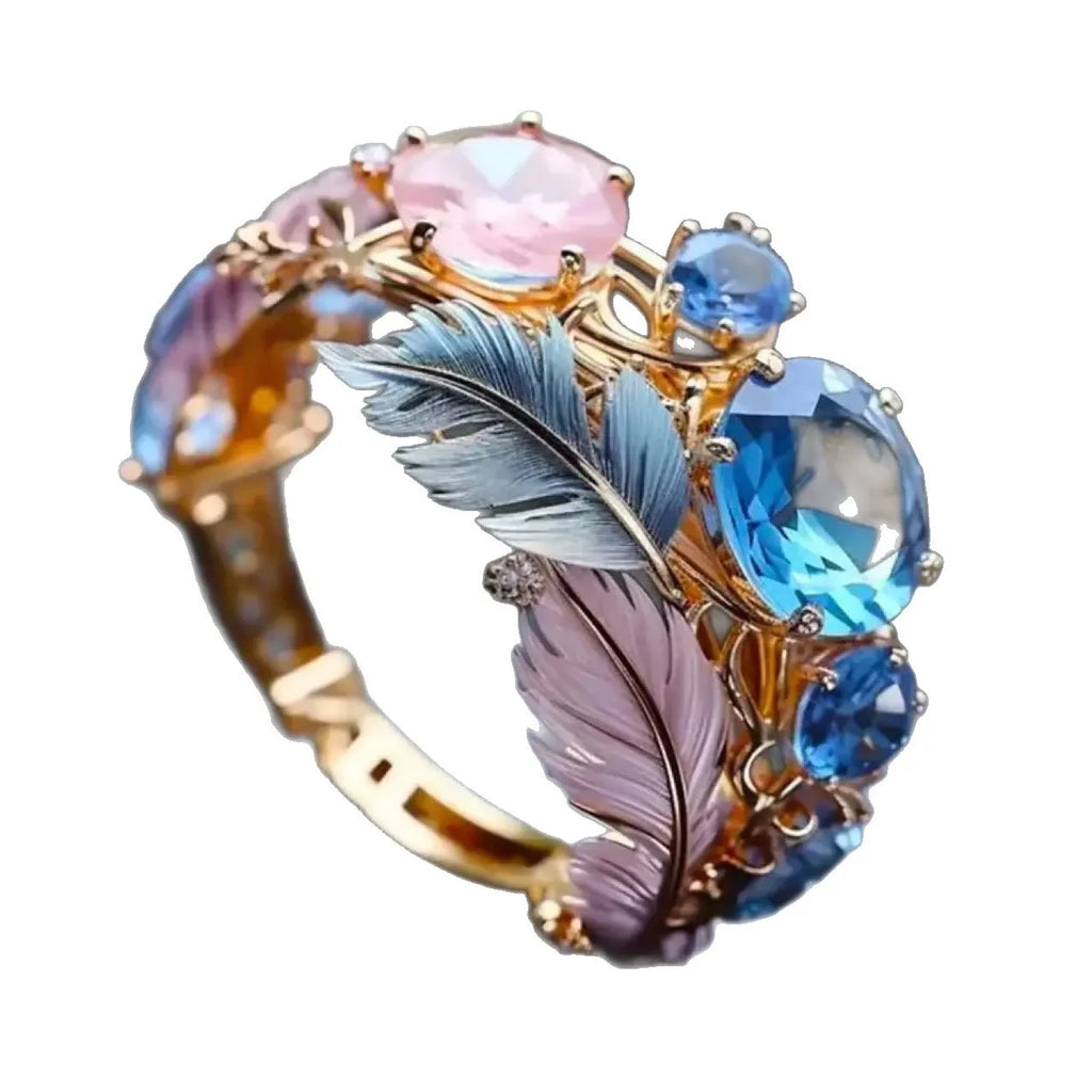 Brass feather ring with embossed colourful design and zircon accents in gold colour