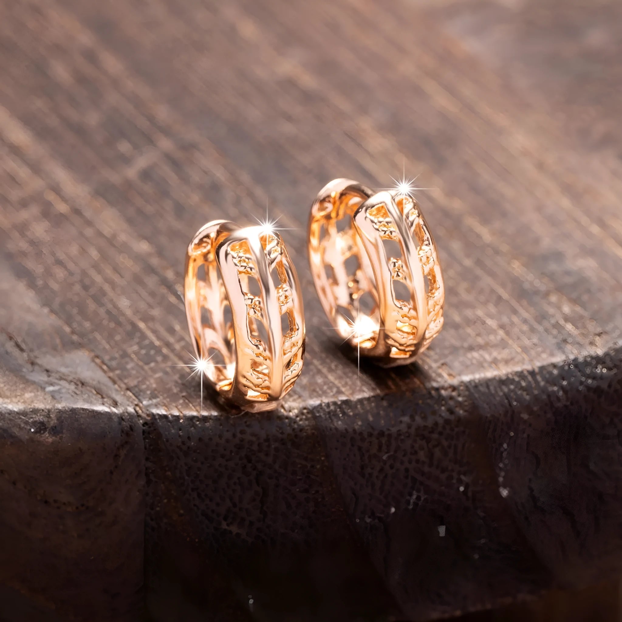 Rose gold hollowed out heart and leaf shaped copper earrings on a white background.