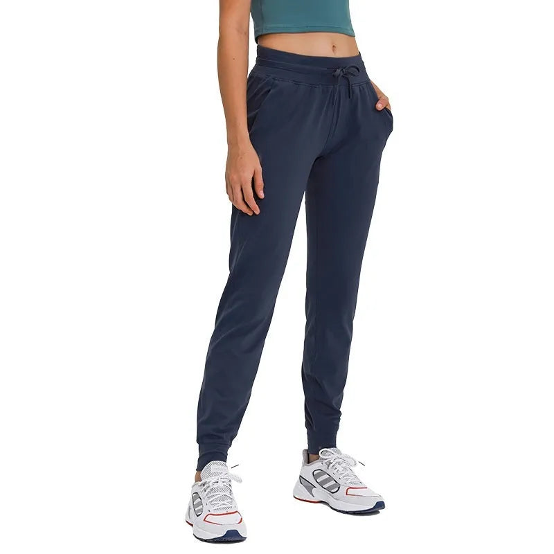 Women's high waist yoga pants with drawstring in navy blue, laid flat to show fit and fabric detail.