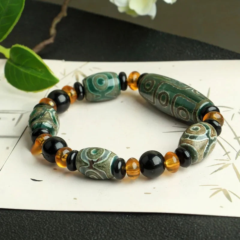 Distressed agate bracelet with traditional Tibetan dzi beads including three-eye and Nine Eyes designs.