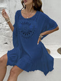 Apricot coloured crochet stitch tassel beach dress on a hanger, showing patchwork skirt design.