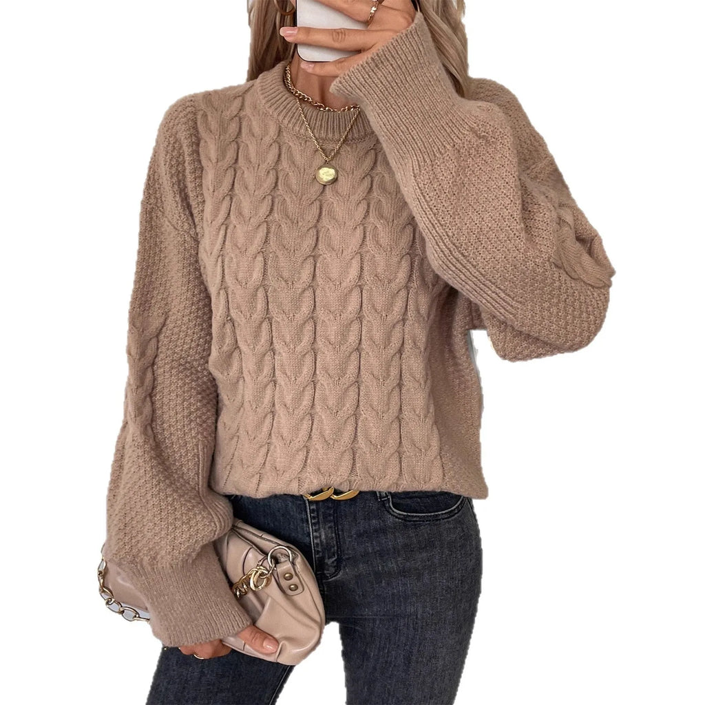Women's beige loose-fitting sweater with twisted detailing on a hanger.
