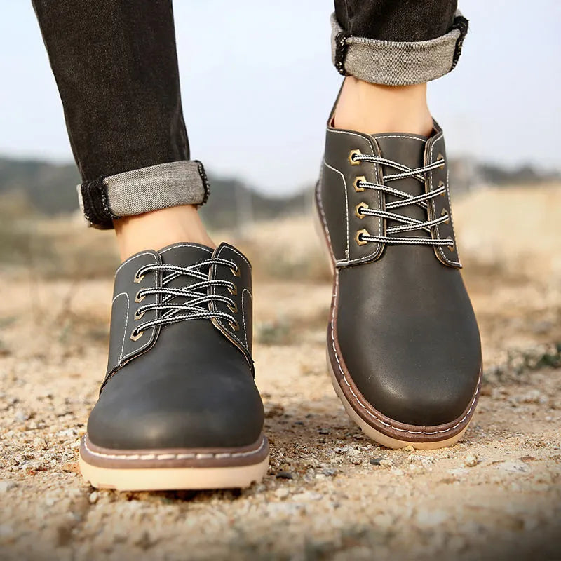Men's black mid-top leather boots with rubber soles showing British tide style and waterproof construction