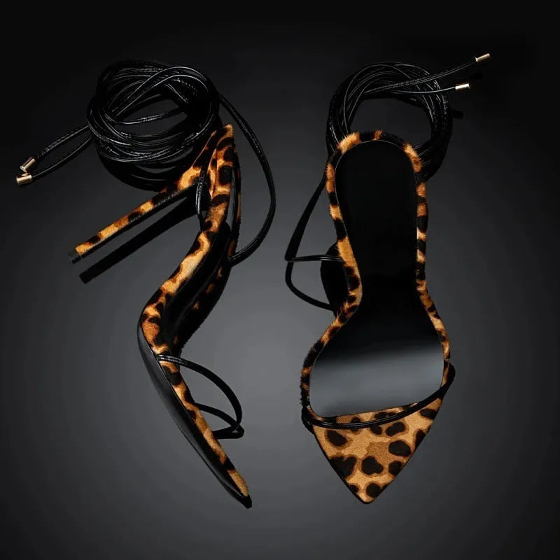 Women's leopard print pointed toe sandals with lace-up buckle straps on a flat rubber sole.