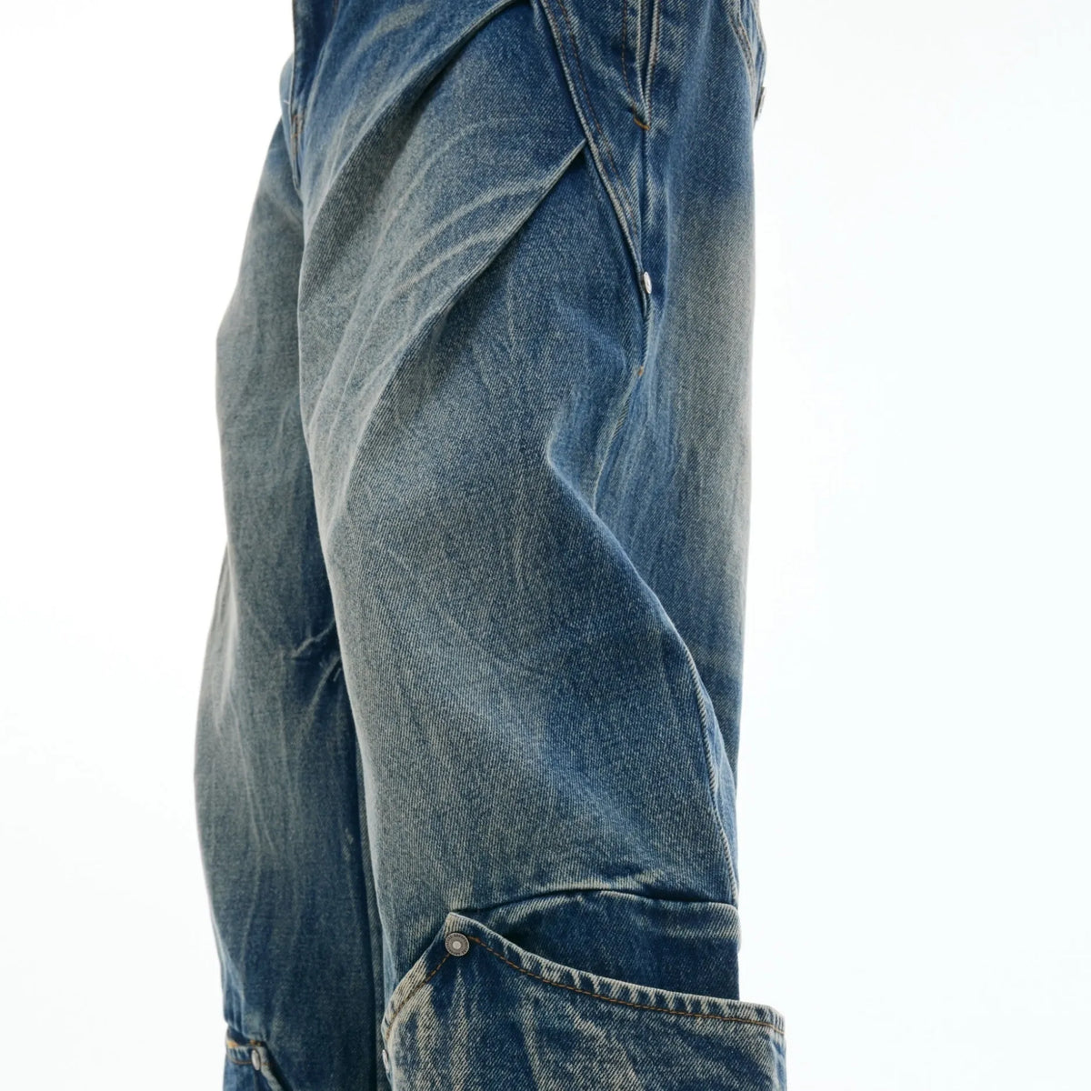 Men's verdant blue jeans with retro washed burst pattern showing curved knife fit and loose styling