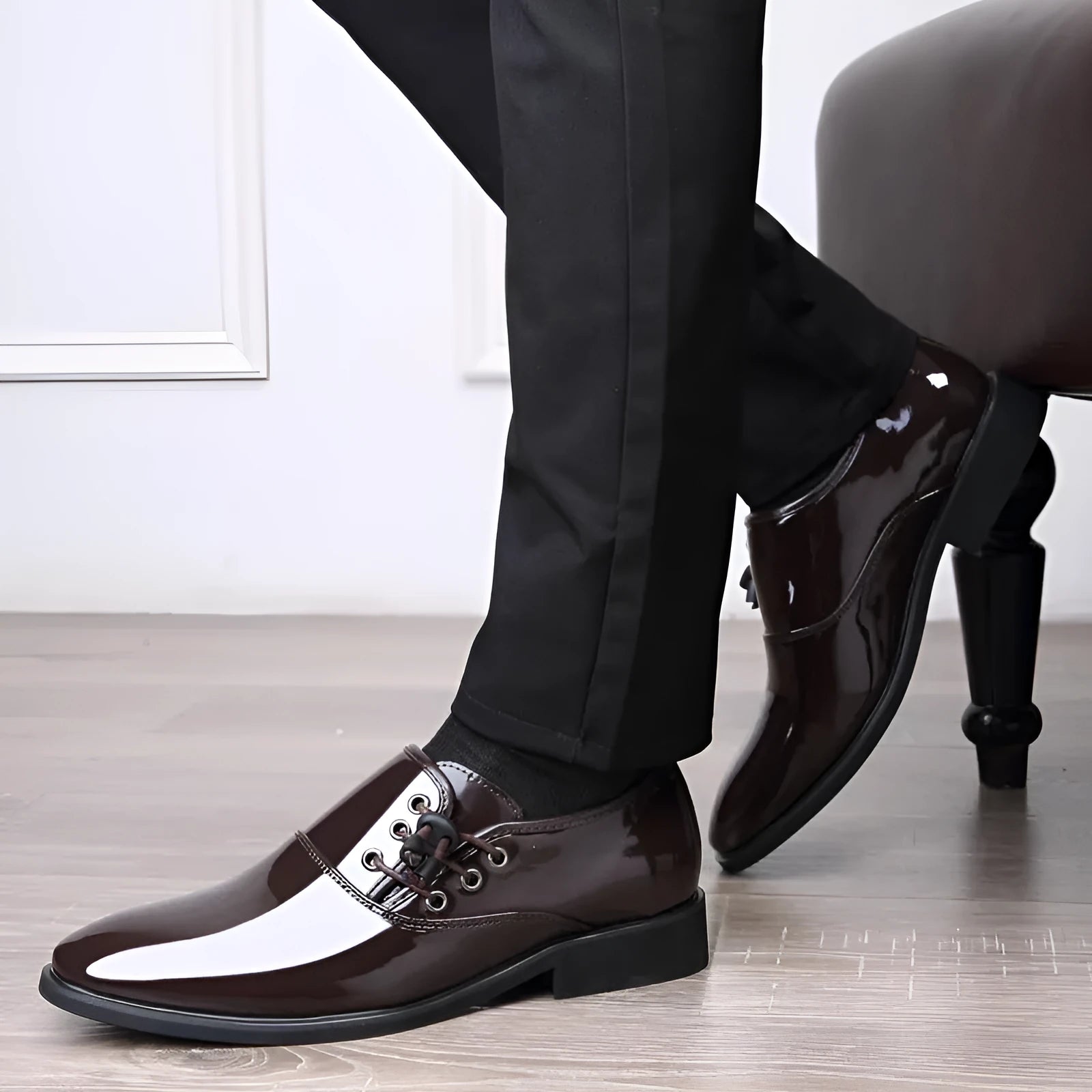 Men's black and brown formal oversleeve shoes with round toe and square heel on a rubber sole.