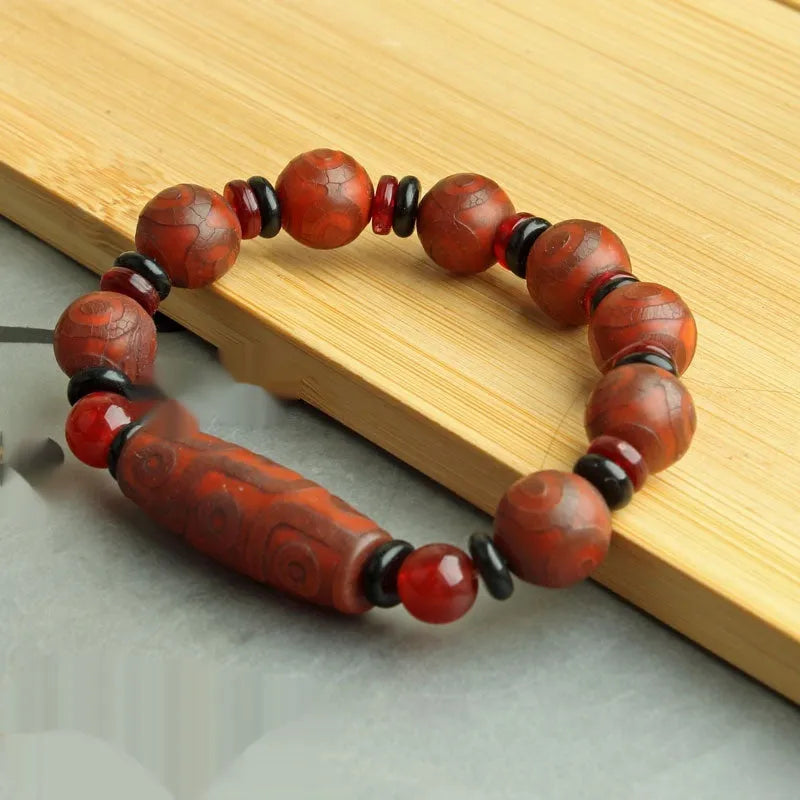 Distressed agate bracelet with traditional Tibetan dzi beads including three-eye and Nine Eyes designs.