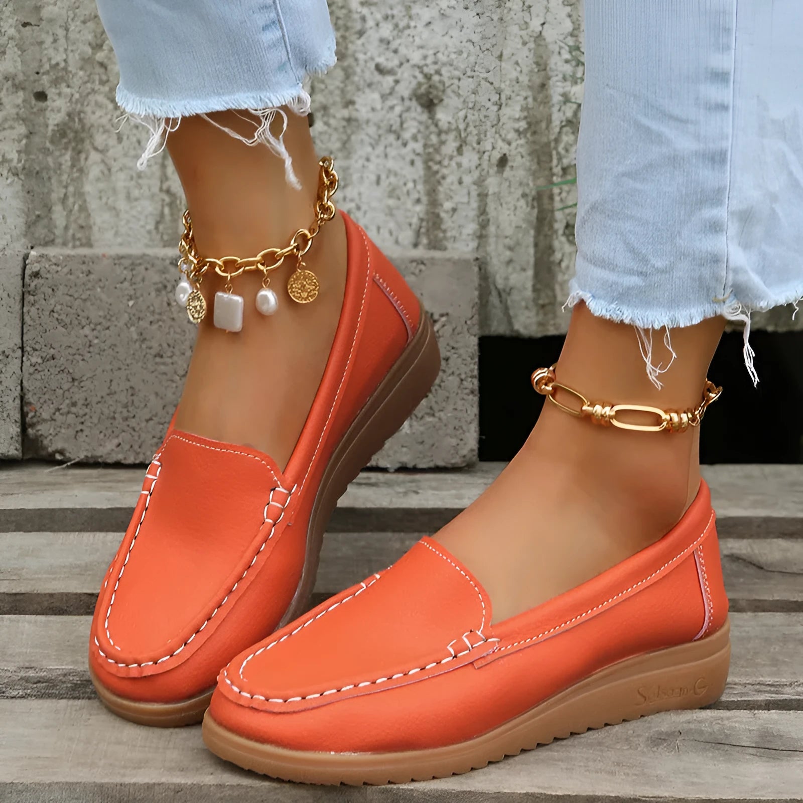 Women's flat slip-on loafers in PU leather with car suture detailing on the upper.