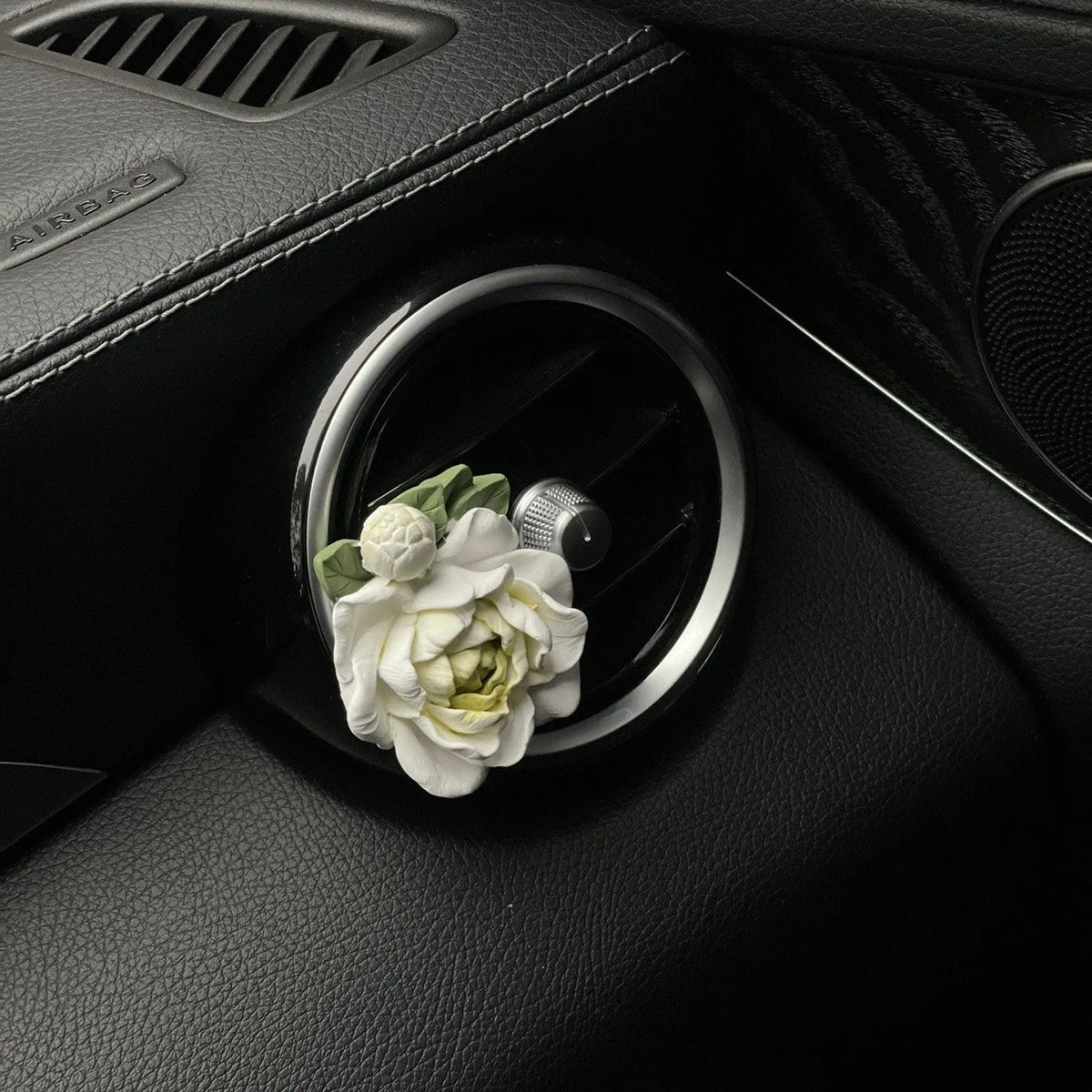 Jasmine scented gypsum solid car perfume clipped to a car air vent in off white or fresh green.