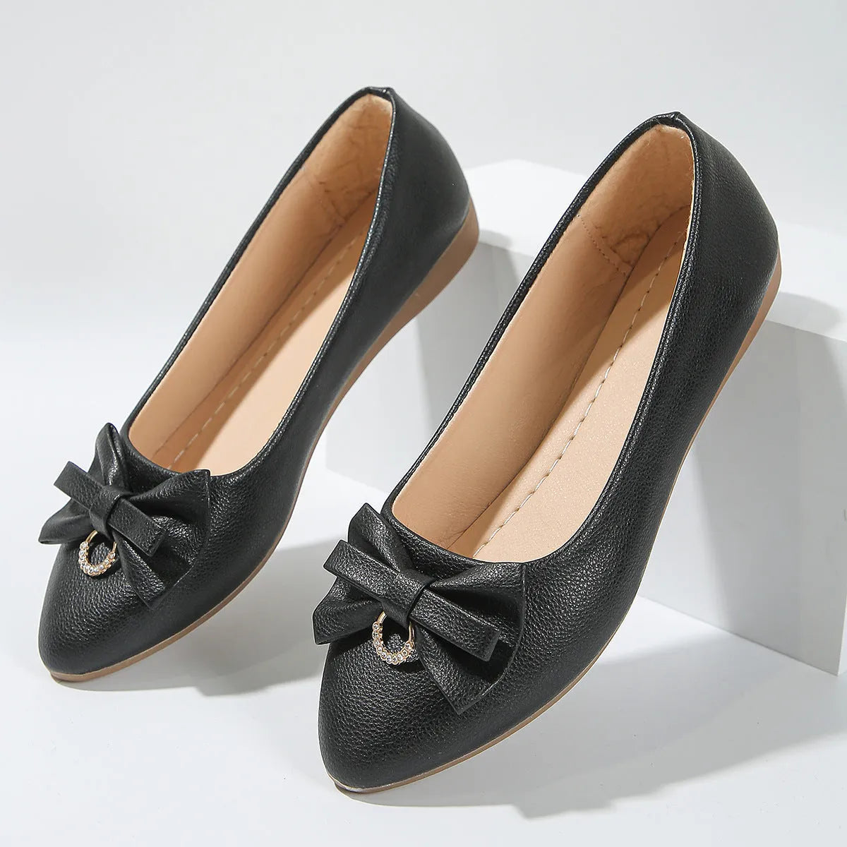 Women's beige casual flat slip-on shoes with a bowknot and shallow mouth design on a rubber sole.