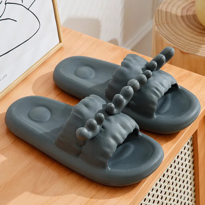 Pair of light-coloured EVA flip flop slippers with hollow-out design and textured sole.