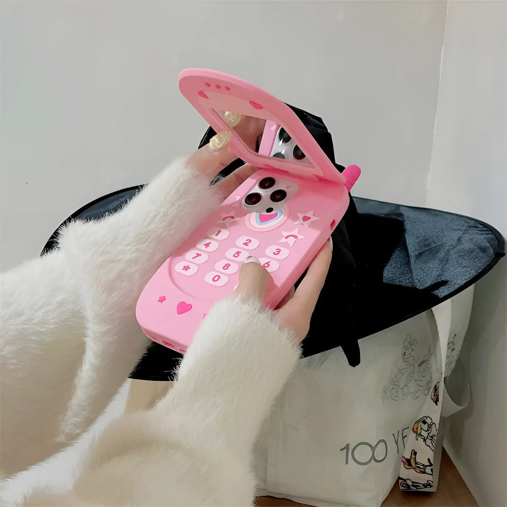 Light pink silicone flip phone case with built-in mirror for iPhone, showing cute cartoon design.