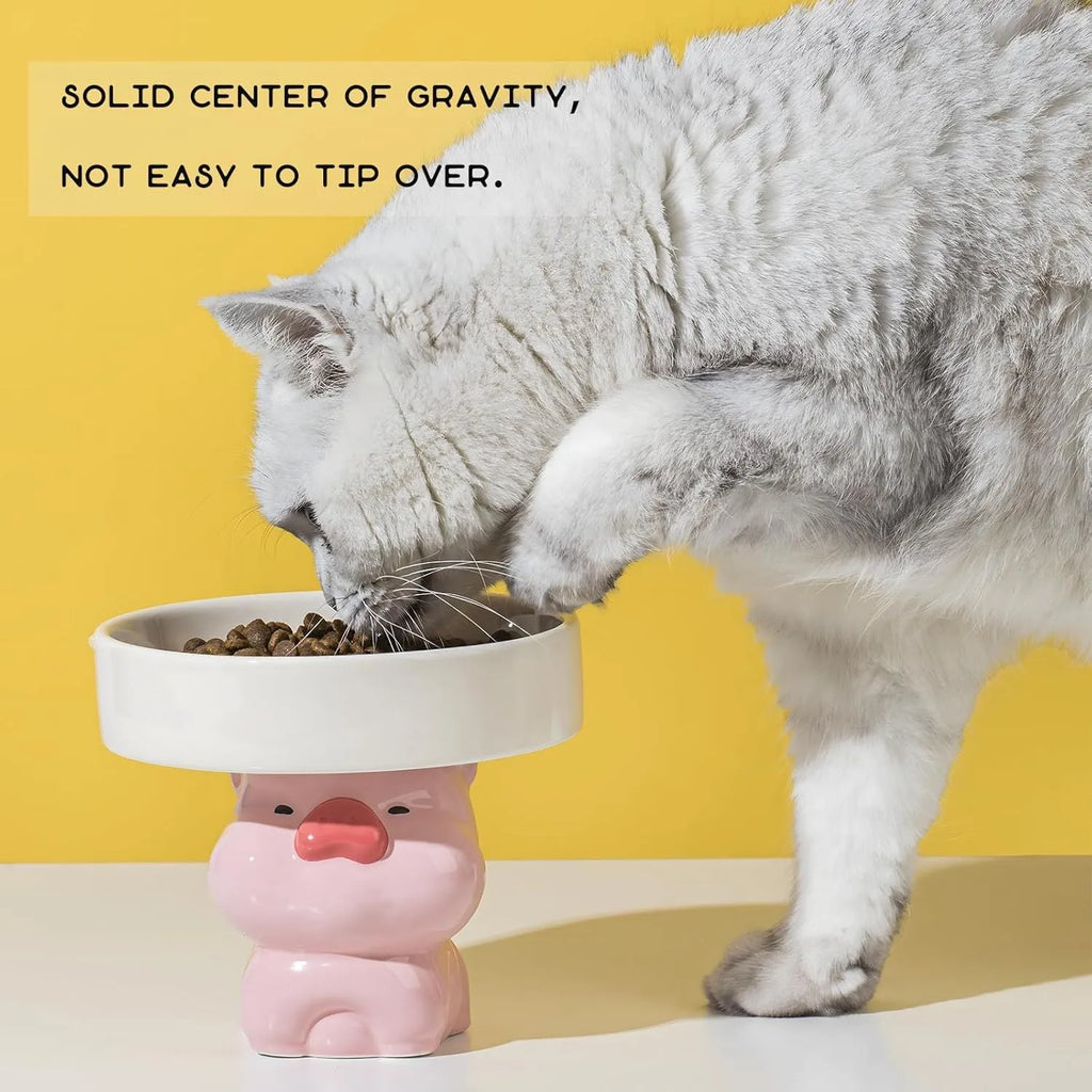 Raised ceramic cat bowl with cute animal design in pink, yellow, or white on a white background