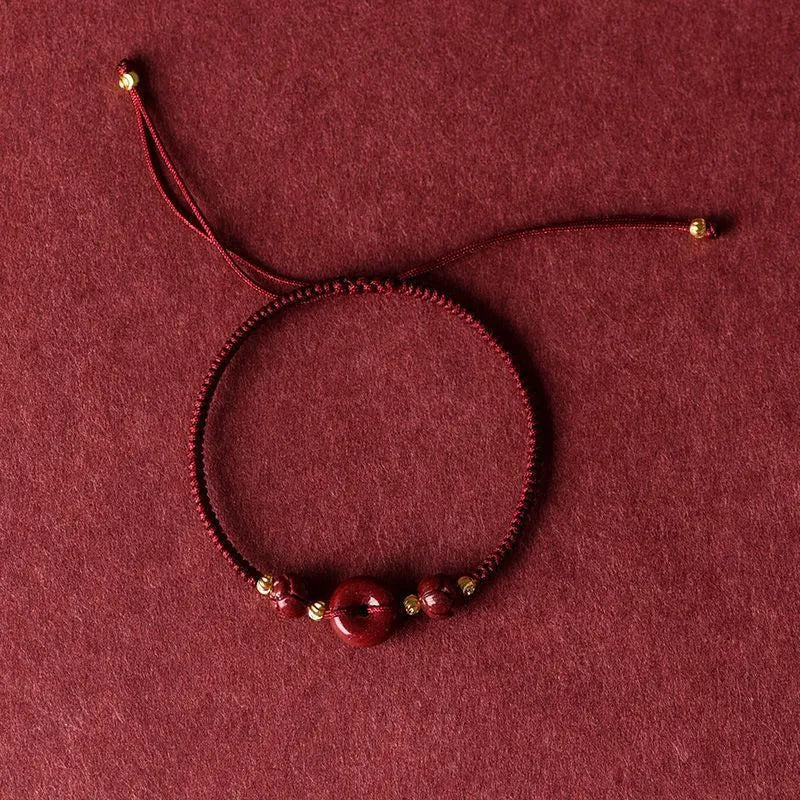 Cinnabar heart-shaped safety buckle bracelet with adjustable knot closure on wrist