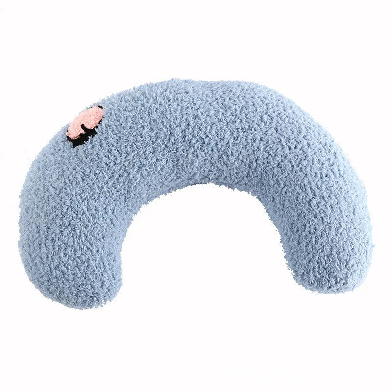 Small blue half-donut shaped pet pillow bed for cats or small dogs on a carpet.