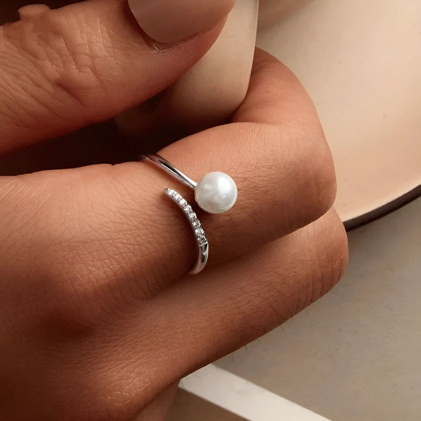 Silver adjustable ring with natural pearl centrepiece showing open loop design