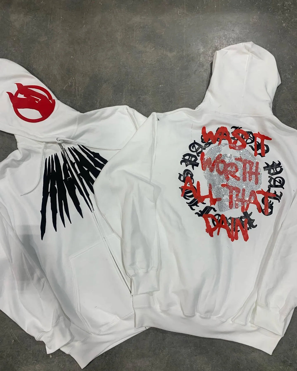 Black loose hooded sweatshirt with a white printed skull and letter design on the front.