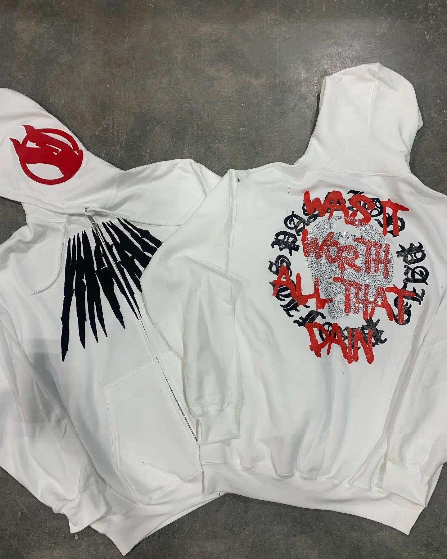 Black loose hooded sweatshirt with a white printed skull and letter design on the front.