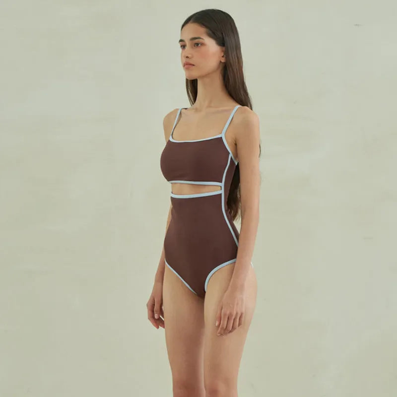 Brown women's one-piece swimsuit with triangle style on a hanger.