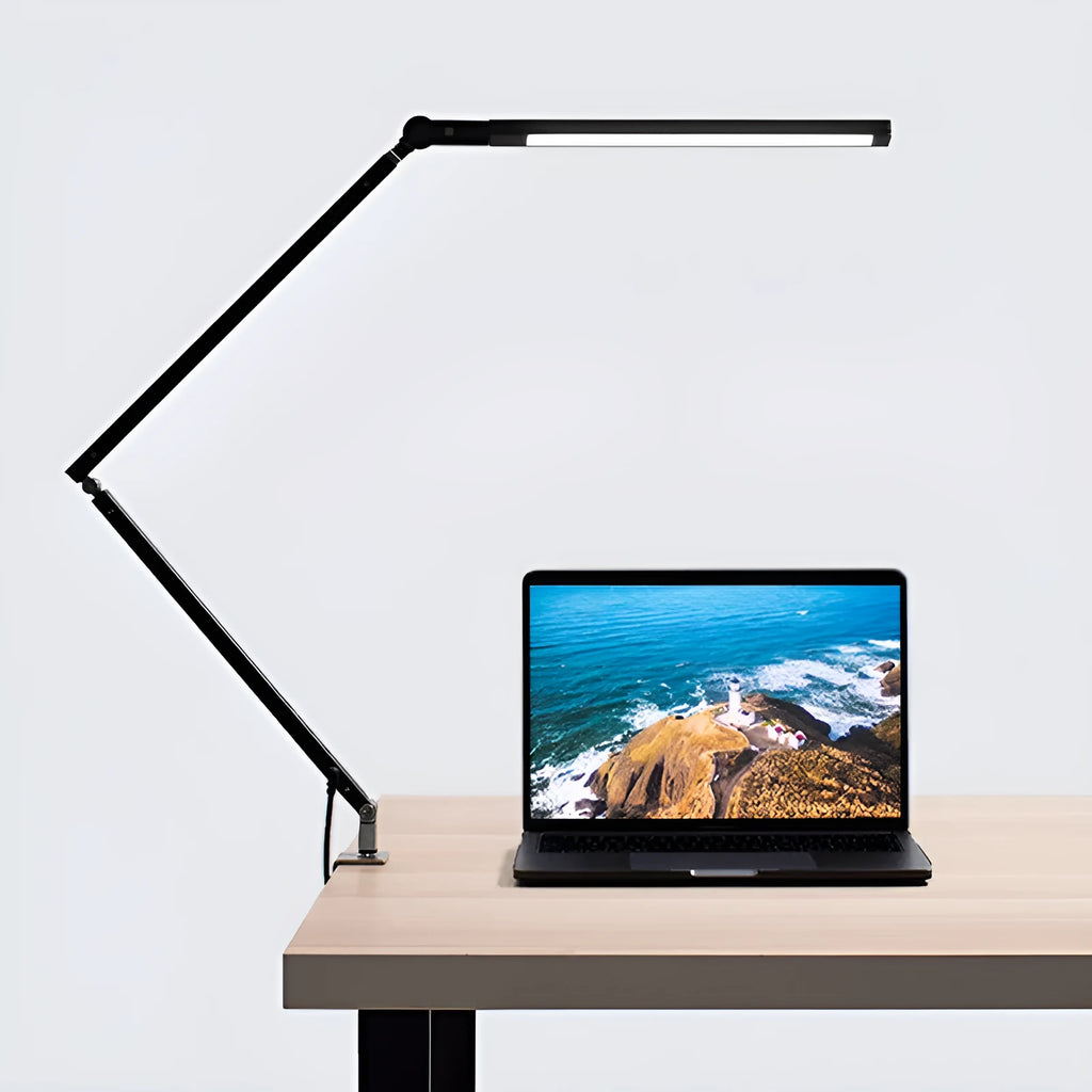 Black folding clip-on LED desk lamp with remote control on a wooden desk.