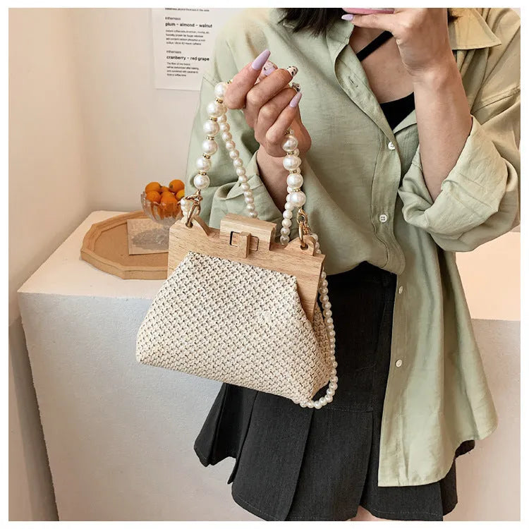 Women's woven straw beach bag with pearl chain shoulder strap in horizontal square shape