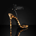 Women's leopard print pointed toe sandals with lace-up buckle straps on a flat rubber sole.