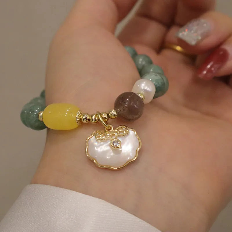 Adjustable green jade bead bracelet with a natural shell clasp fastening.