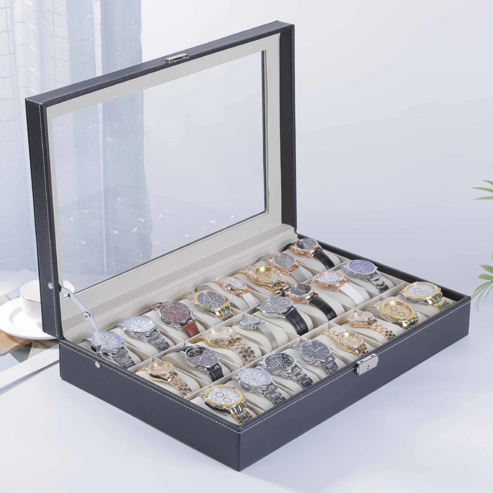 Grey leather watch storage box with transparent lid showing internal watch slots.
