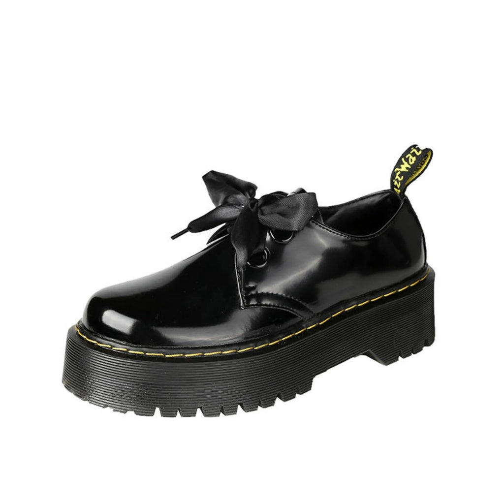 Women's black thick-soled leather shoes with cross-strap closure and ribbon detailing