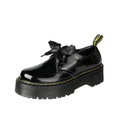 Women's black thick-soled leather shoes with cross-strap closure and ribbon detailing