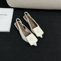 Women's low heel pointed toe sandals with a back strap in black, shown from the side.