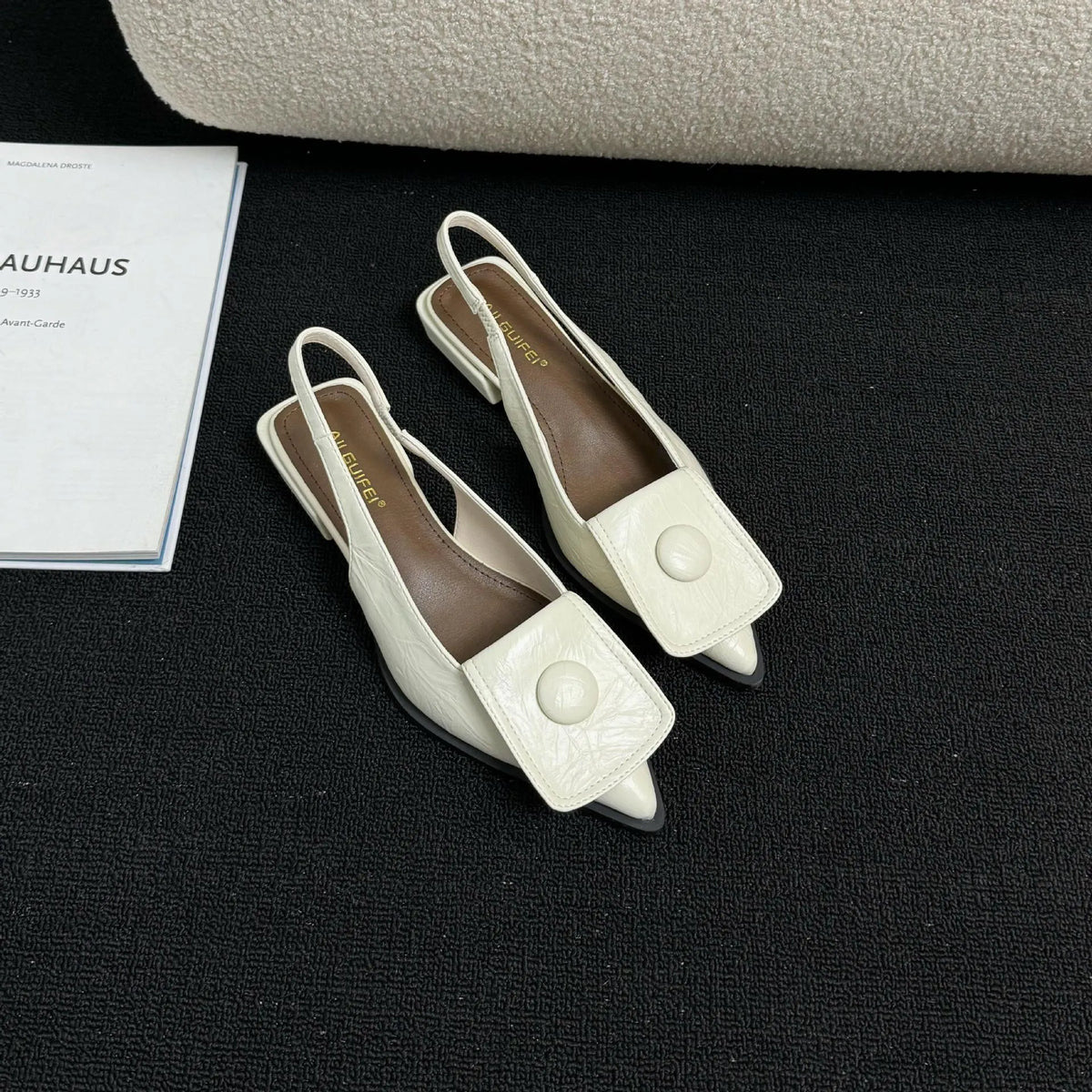 Women's low heel pointed toe sandals with a back strap in black, shown from the side.