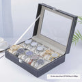 Grey leather watch storage box with transparent lid showing internal watch slots.