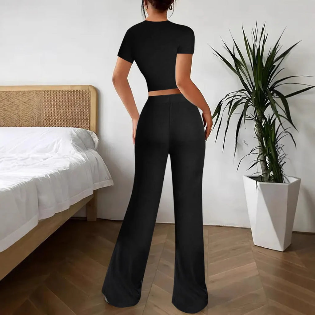 Women's black high waist trousers and regular sleeve t-shirt two-piece set laid flat.