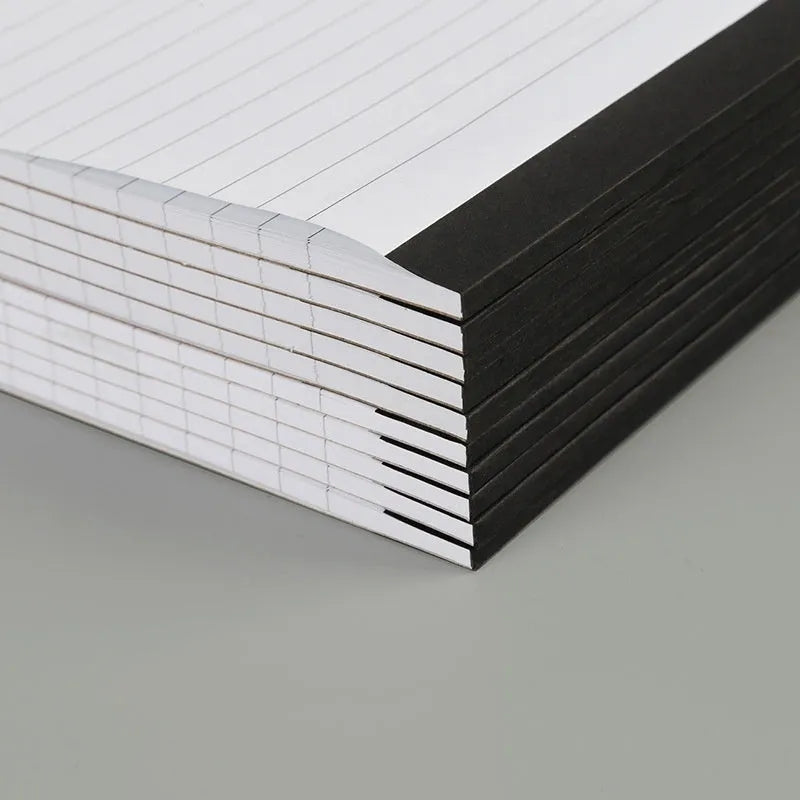 A4 tearable notebook with grid-lined pages and paper cover, showing adhesive binding.