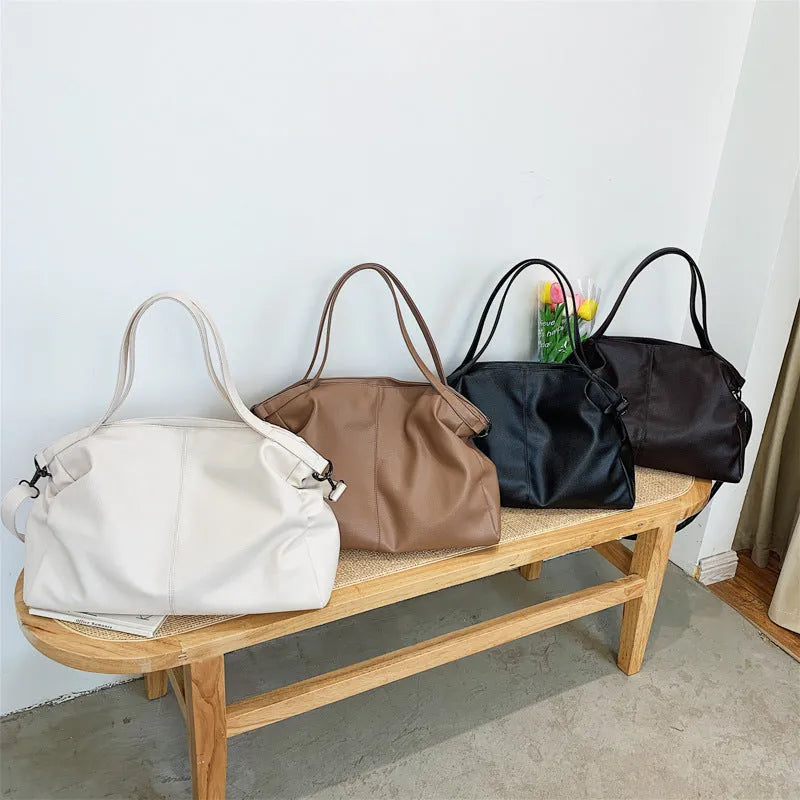 Large soft surface messenger bag in horizontal square shape with adjustable shoulder strap and zipper opening