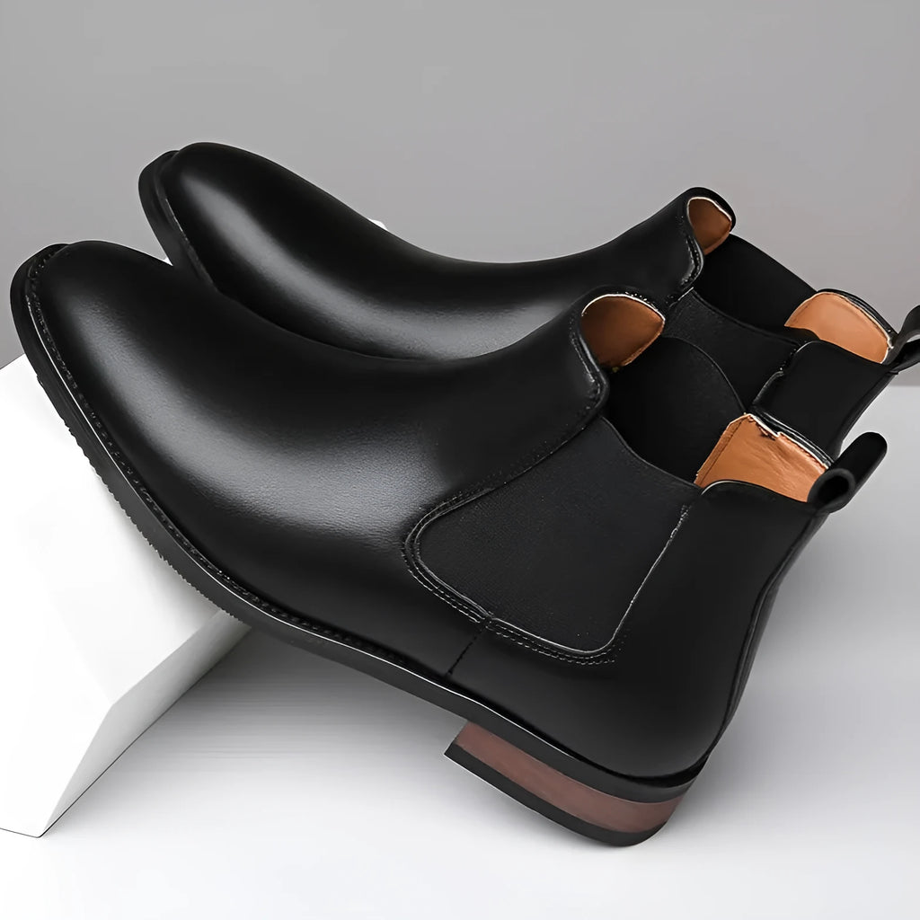 Men's black pointed-toe Chelsea ankle boot with a high-top silhouette and rubber sole.