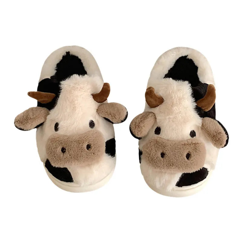 White plush cow slippers for women with black spots, a smiling face, and a textured non-slip sole.