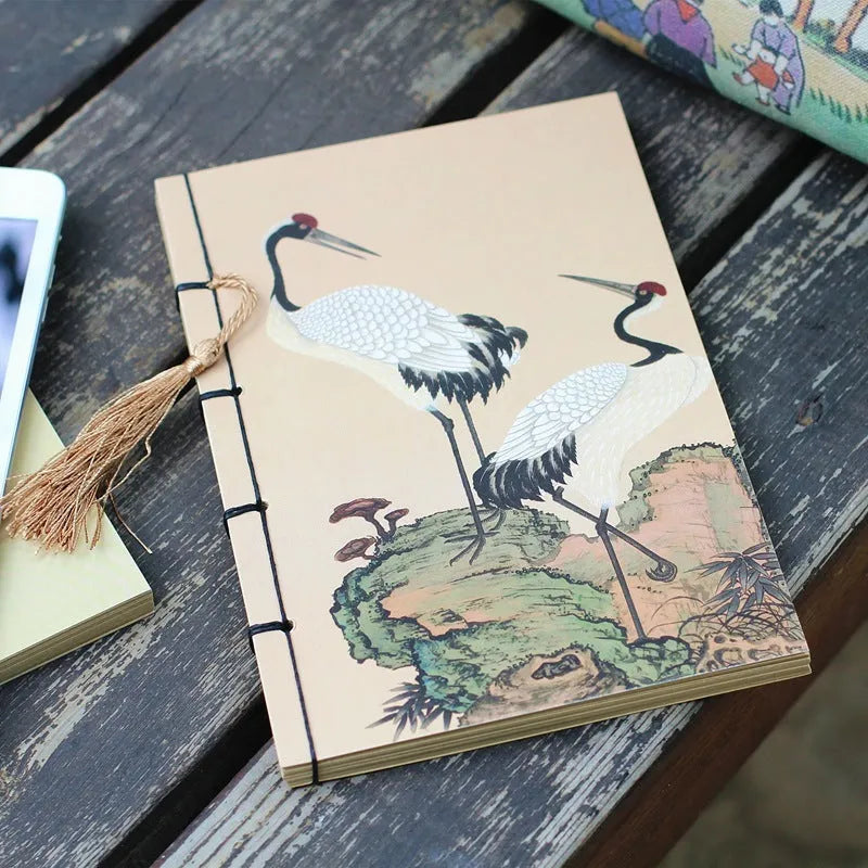 A5 antique wire-bound notebook with glossy embossed cover featuring a retro painting design, shown open.