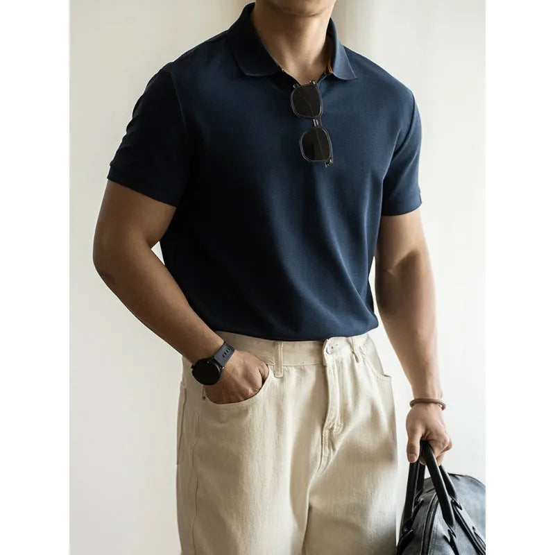 Man wearing a classic blue short-sleeved cotton blend polo shirt, showing regular fit and button placket.
