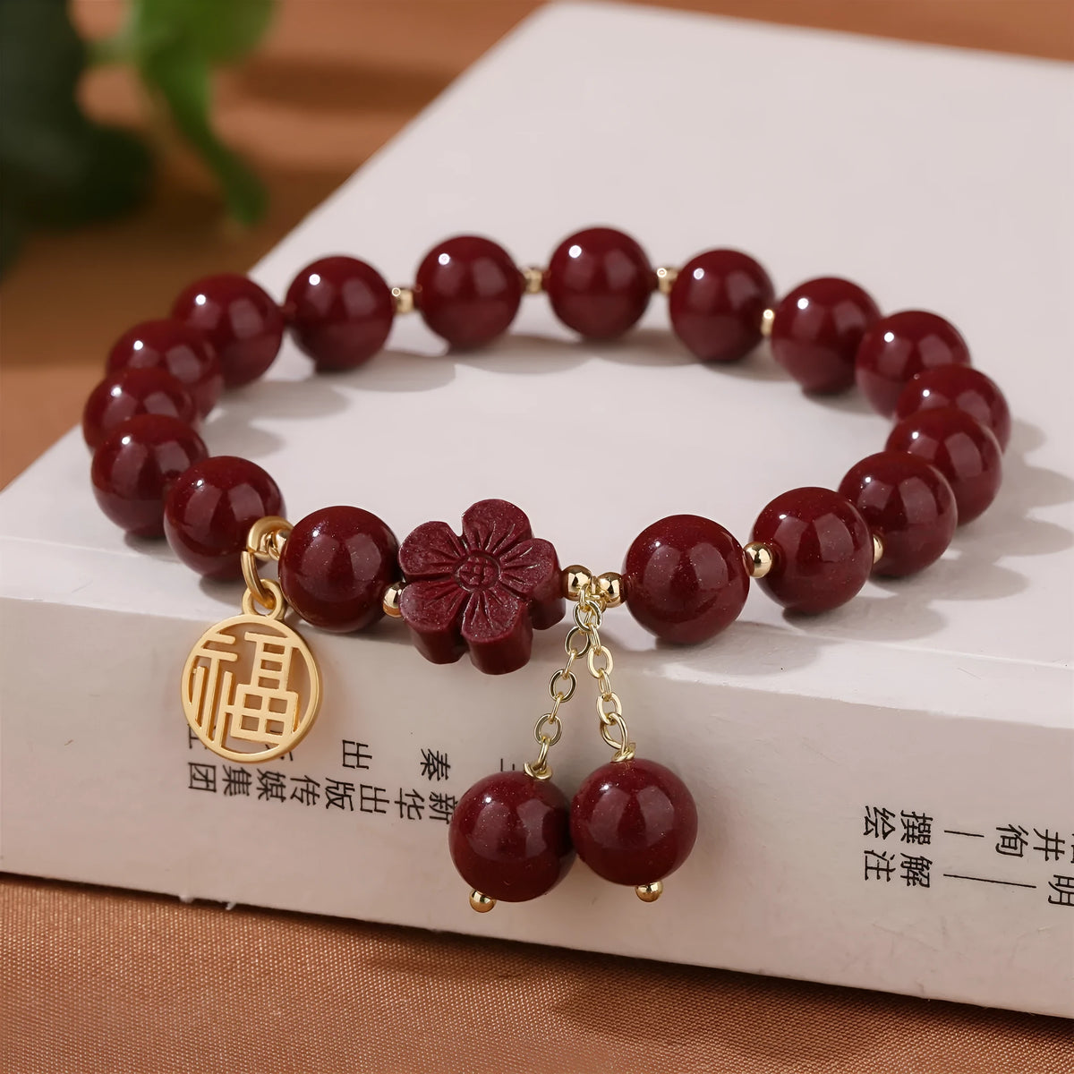 Women's cinnabar and purple gold sand bracelet with Fu character peach blossom or Hetian jade flower national style design and tassel detailing