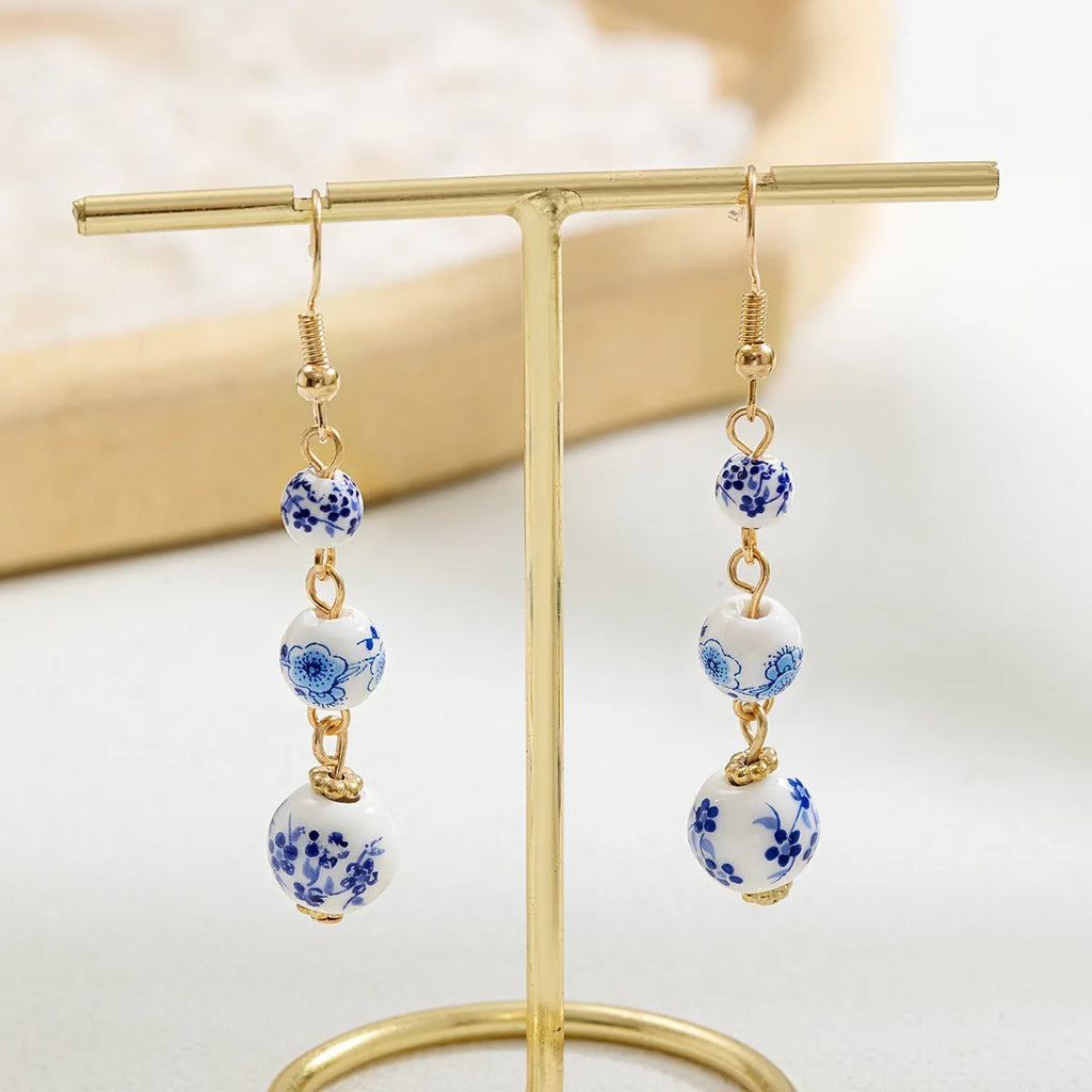 Long blue and white porcelain ceramic bead earrings with geometric Chinese-style design.